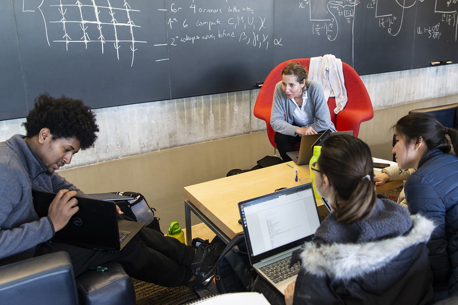 Gebremedhin Dagnew working with thee other students on a problem in a conference room