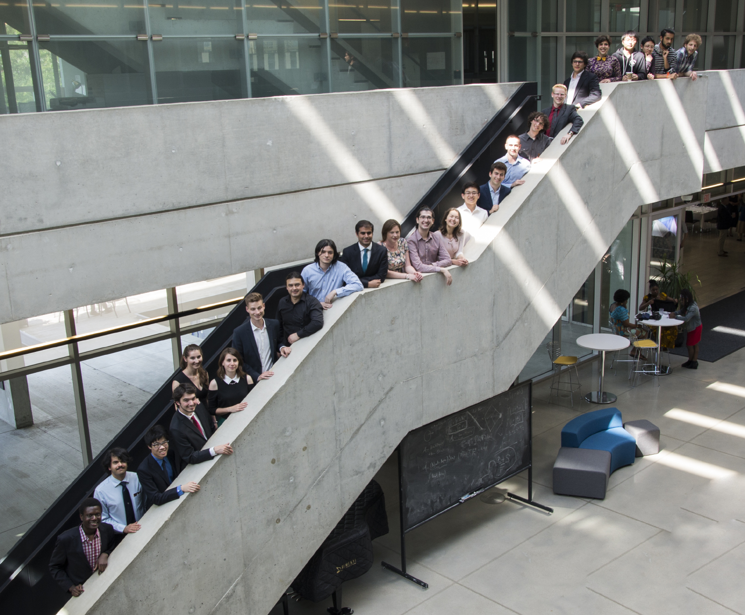 PSI class of 2017 posing in a row on the stairs of Perimeter Institute's atrium