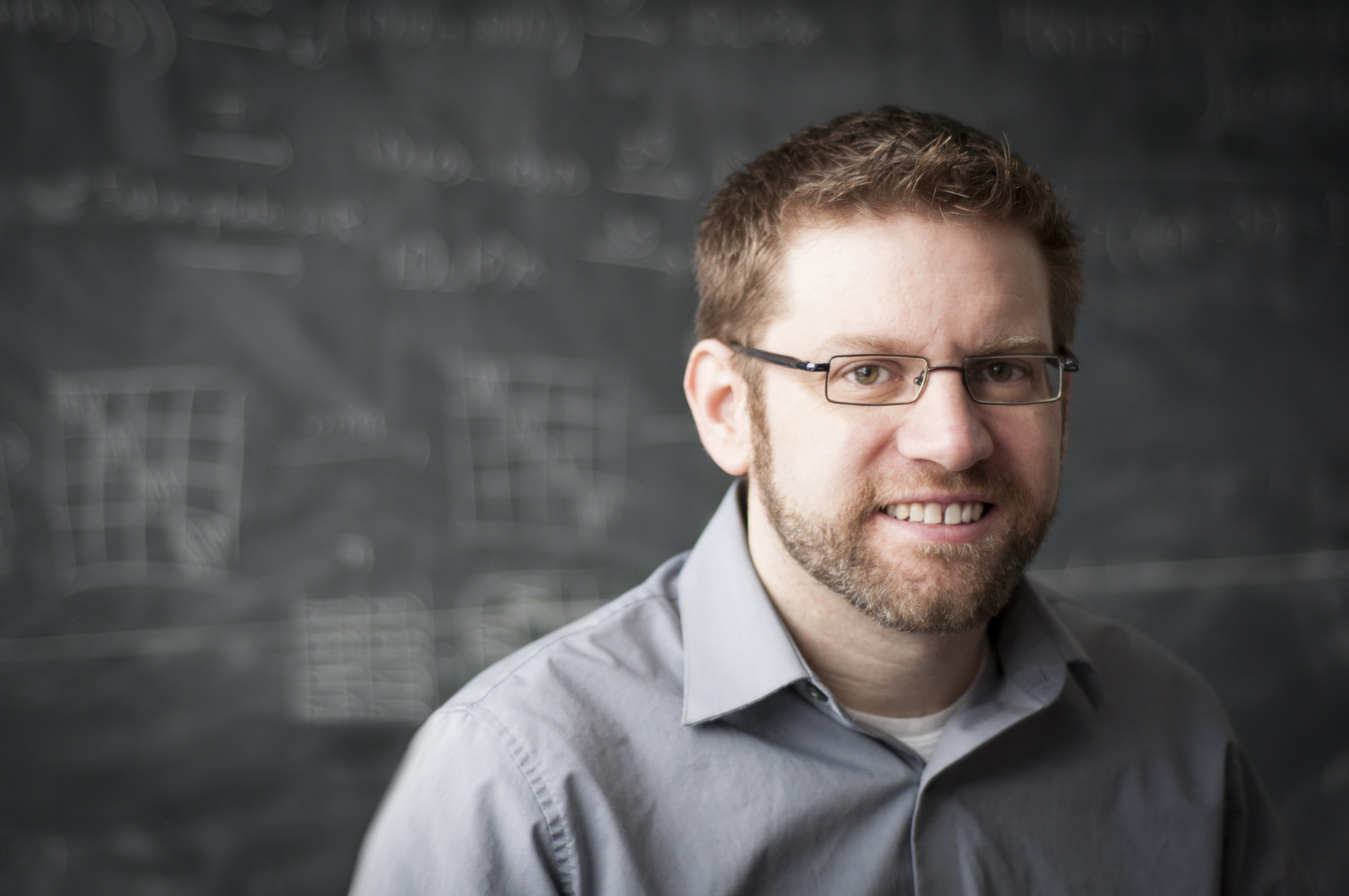 Portrait of Rob Spekkens in front of a blackboard