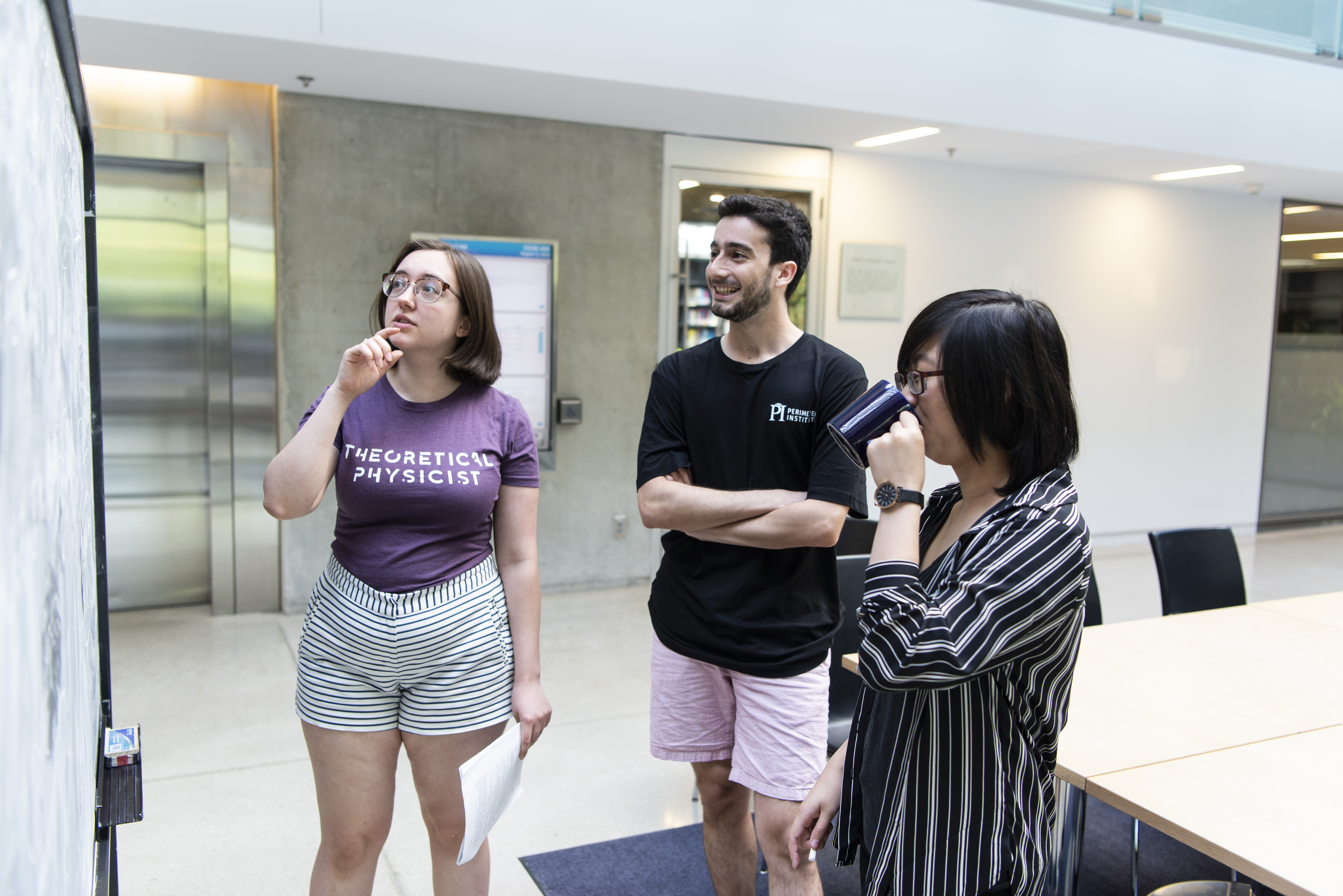 Anya Forestell, Nicolas Valdes, and Serene Shum collaborating on a problem at a chalkboard.