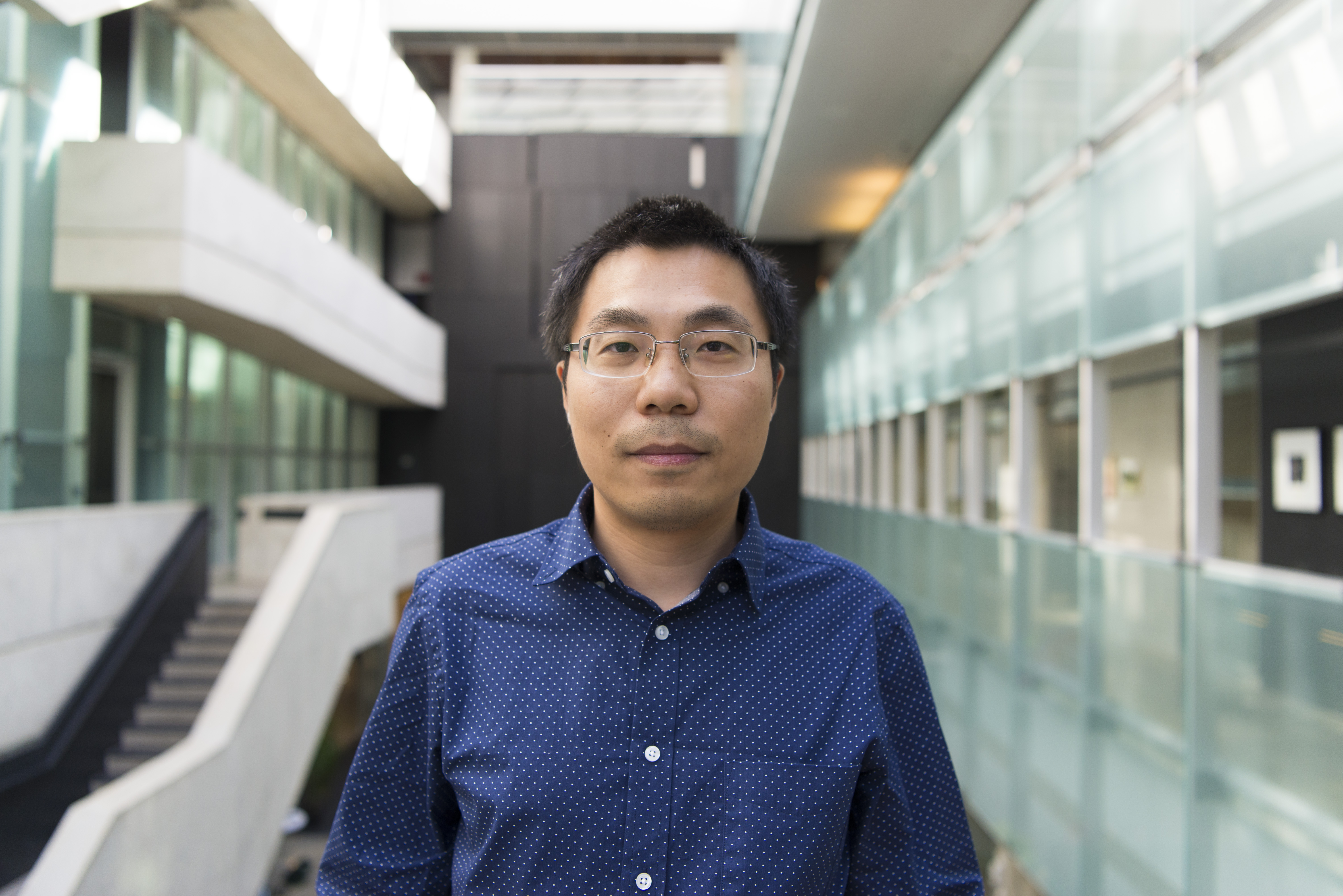 Portrait of Yin-Chen He in front of Perimeter Institute's atrium