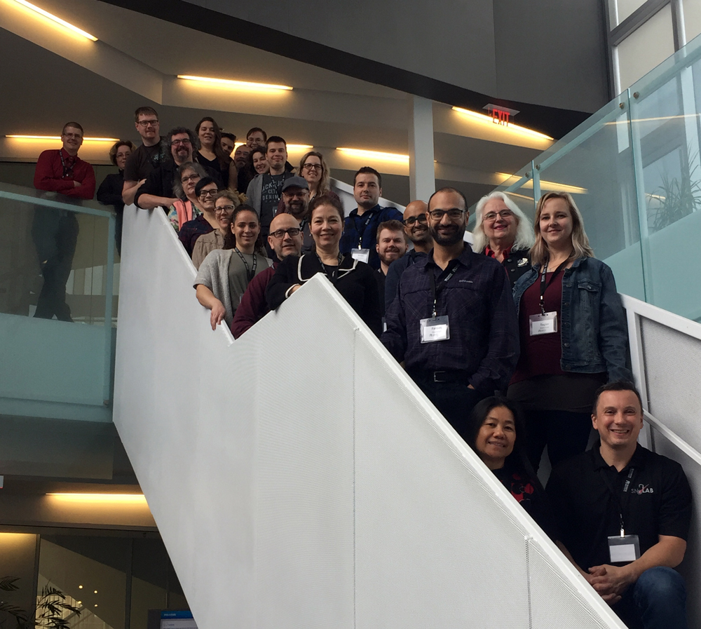 Group of about 25 teachers in the network standing on a staircase