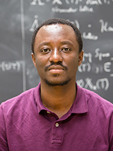 Portrait of a man in front of a blackboard of equations