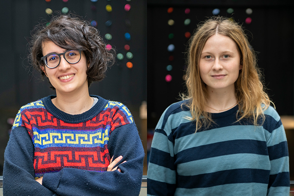 Two young women wearing blue sweaters standing in an atrium