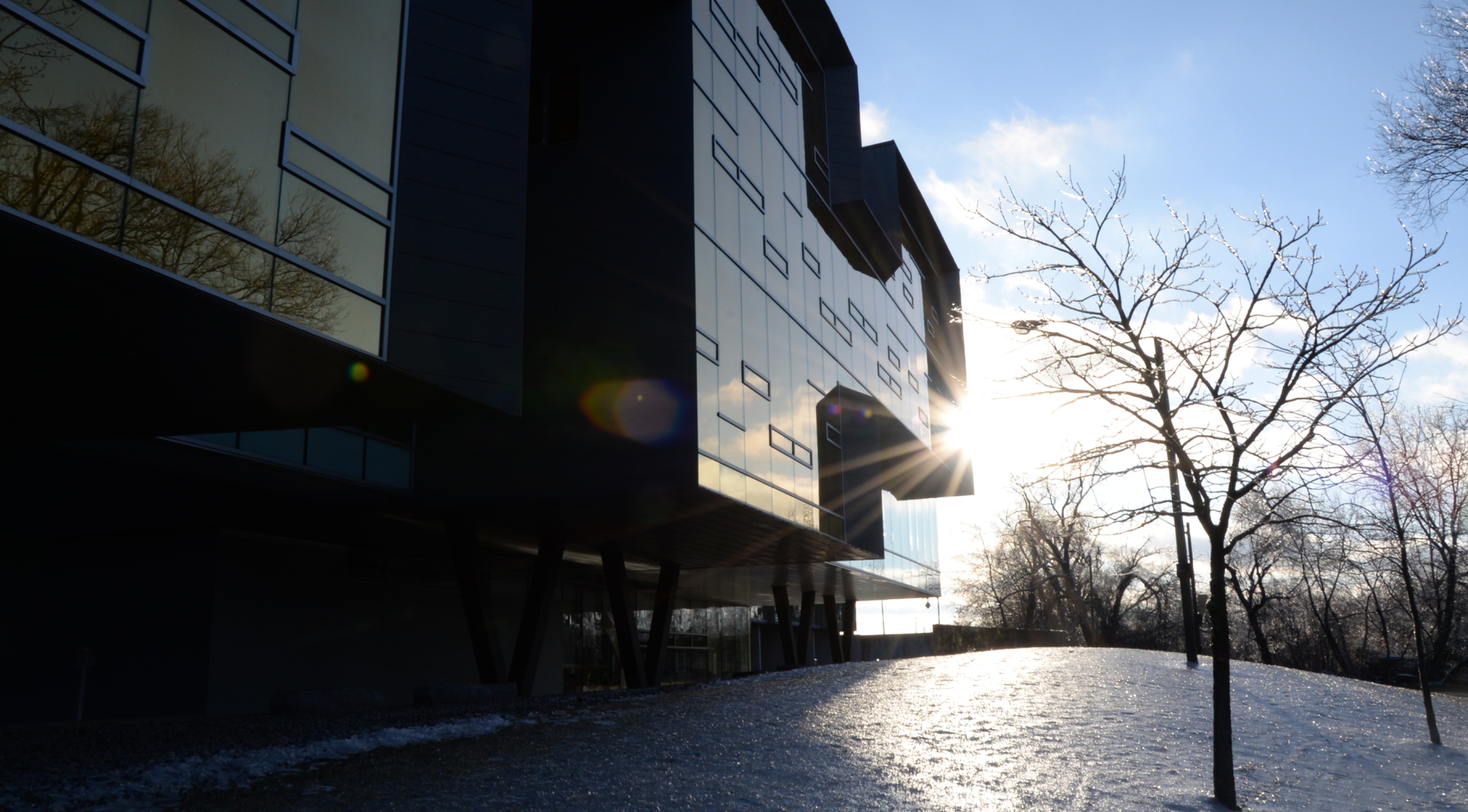 Outdoor shot of building with sun peaking out in winter