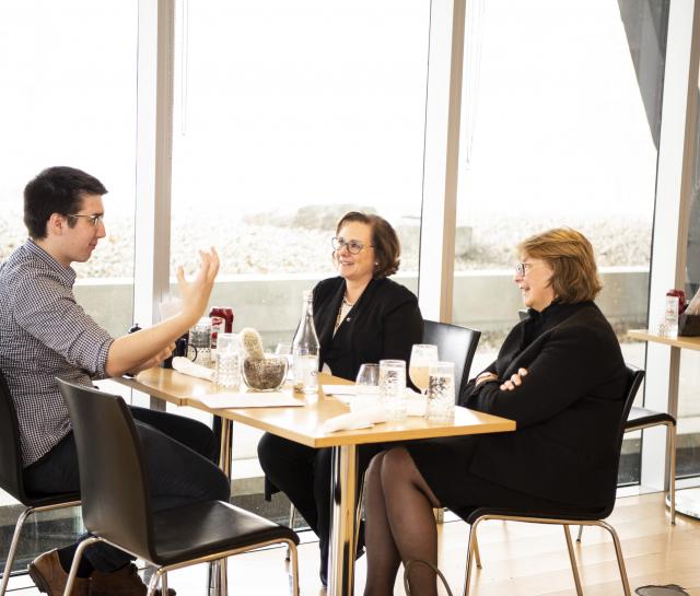 Two women and man talking over lunch