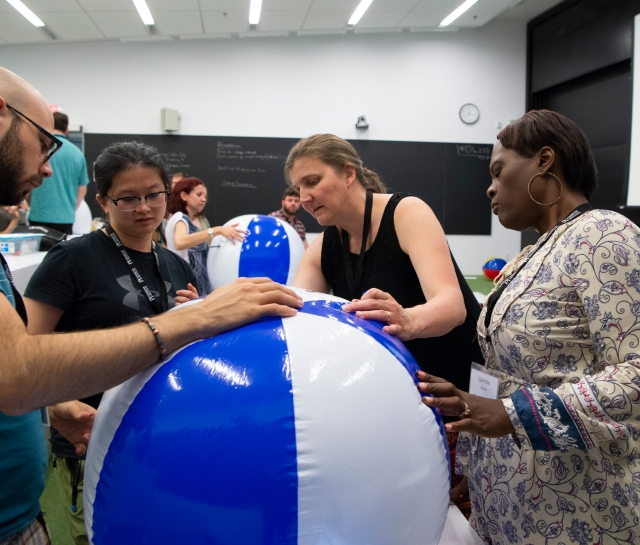 Four teachers working together on an activity with a beach ball