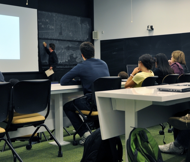 Students sitting classroom style in lecture room listening to teaching