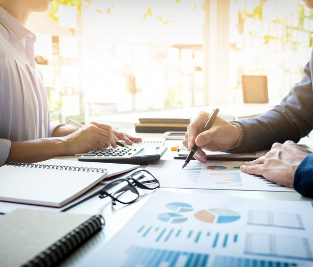 Woman and man sitting at table together working on financial statements