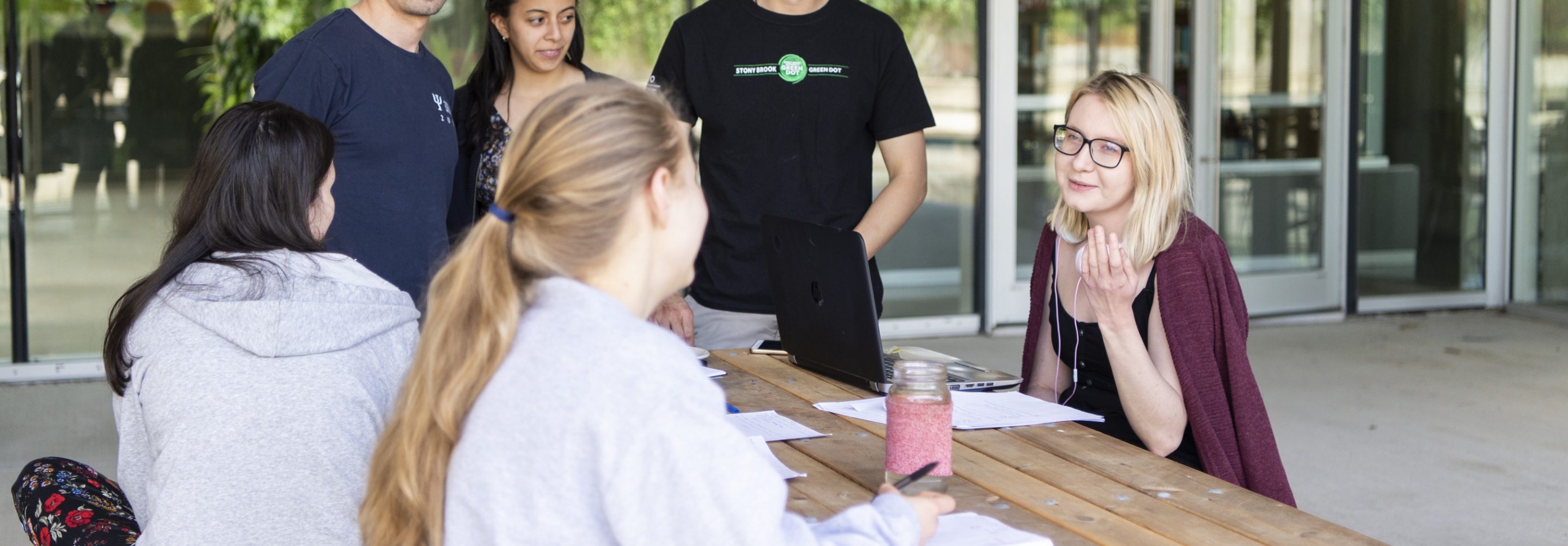 Students sitting at a picnic table discussing science