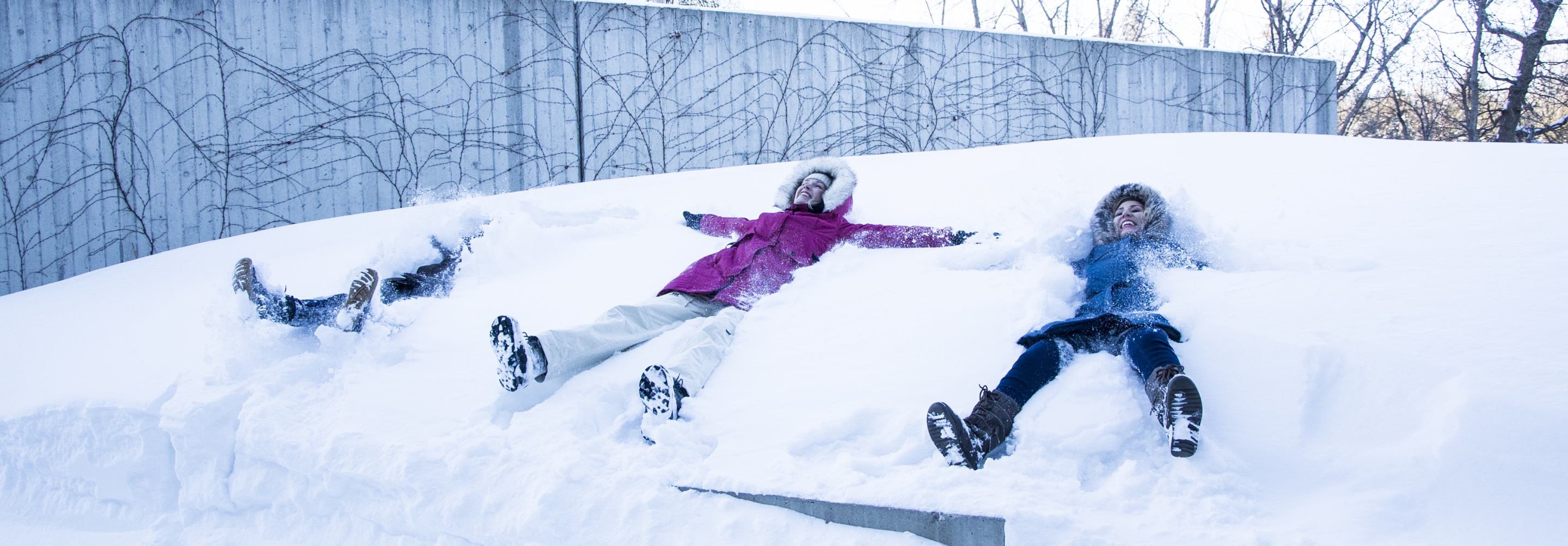 students making snow angels in front of the Perimeter Institute building