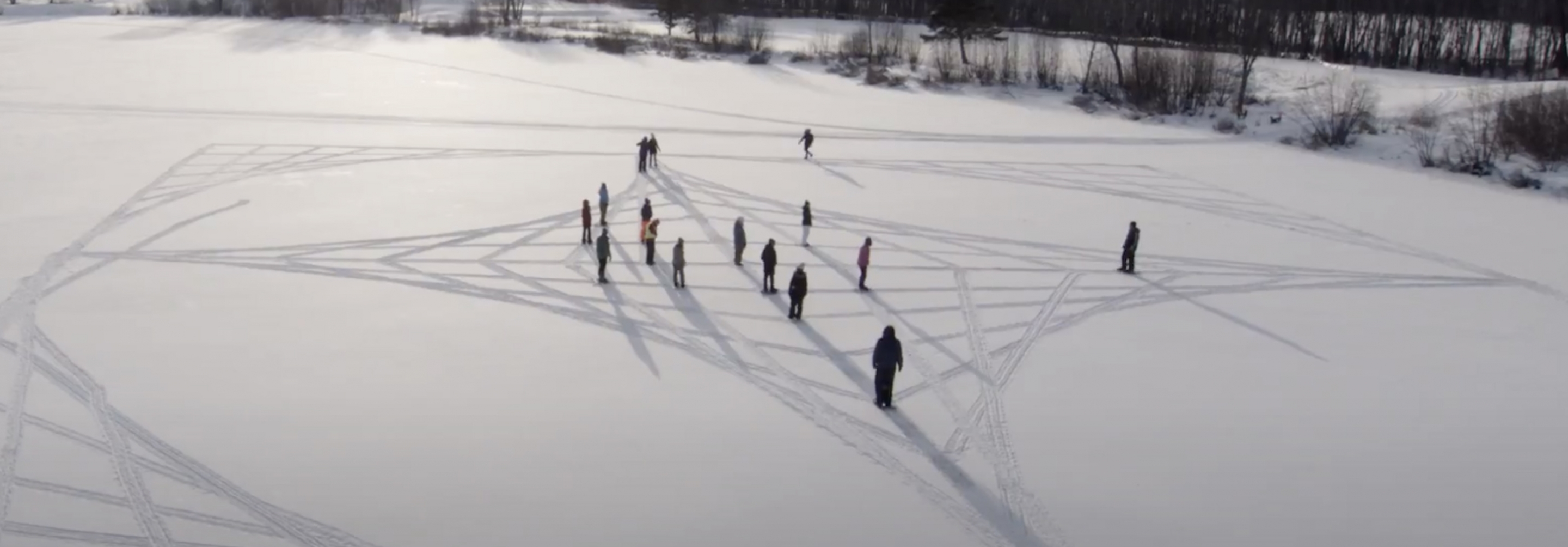 Students making symbols in a field of snow