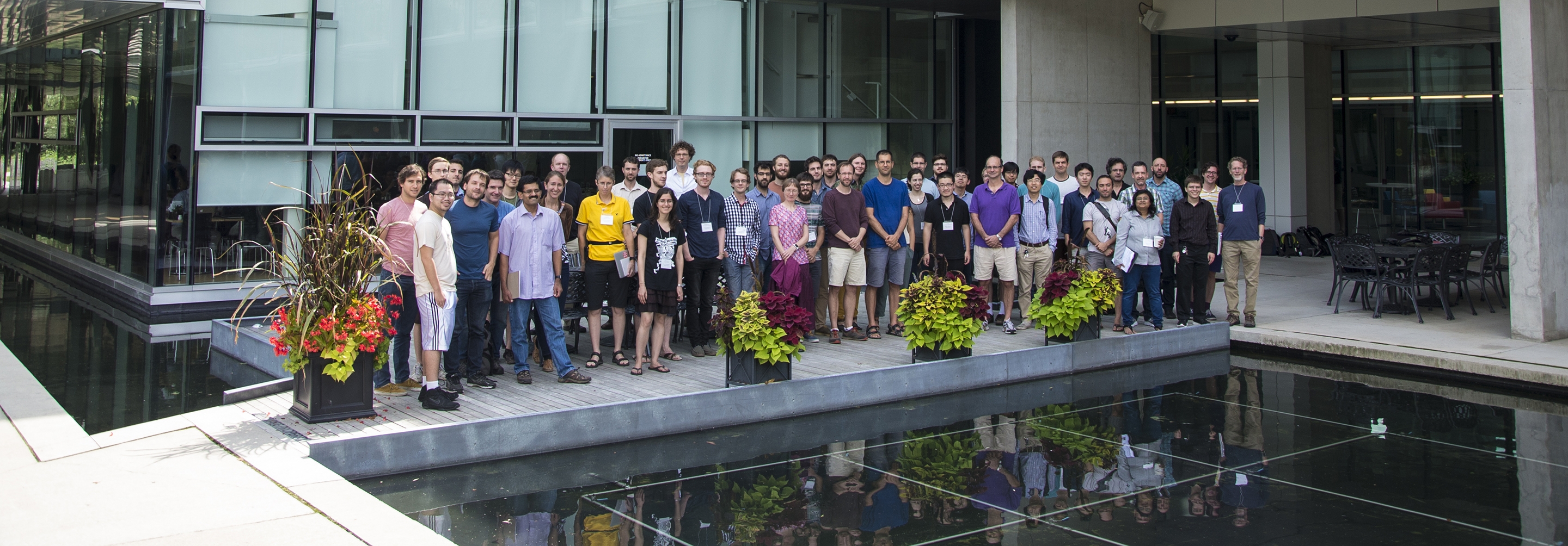 Group of people posing for group photo outside glass building