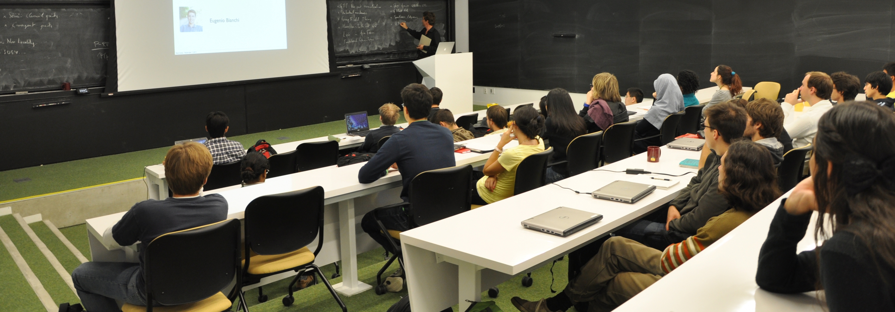 Students sitting classroom style in lecture room listening to teaching