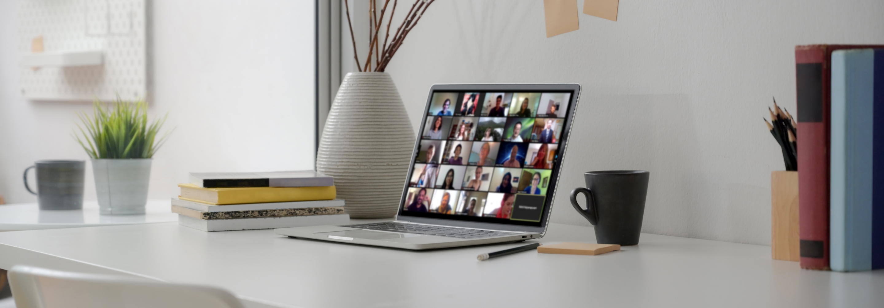 Laptop screen with zoom meeting of faces on a desk in a home office