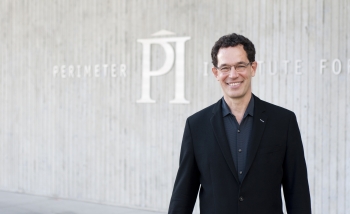 Portrait of Neil Turok standing in front of Perimeter Institute's building facade