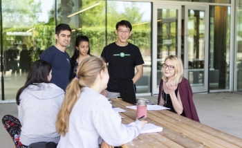 PSI students working together on the patio outside the building