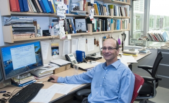 Rob Myers sitting behind his desk at Perimeter Institute