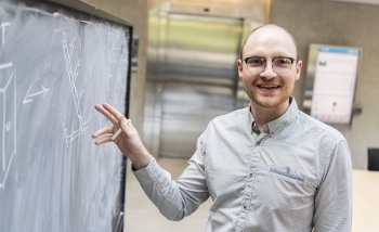 Perimeter Institute postdoc Sebastian Steinhaus talking in front of a blackboard