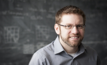 Man smiling infront of chalk board