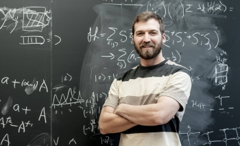 Man smiling infront of chalk board