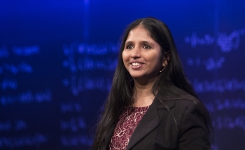 Woman smiling off in the distance in front of blackboard