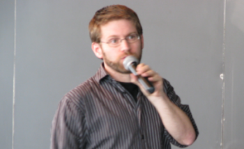 Man speaking infront of chalkboard