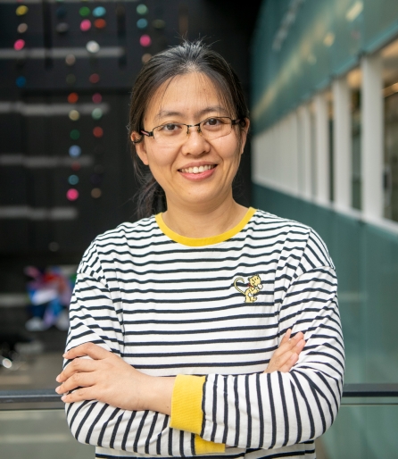 Portrait of a woman wearing a striped shirt standing in an atrium