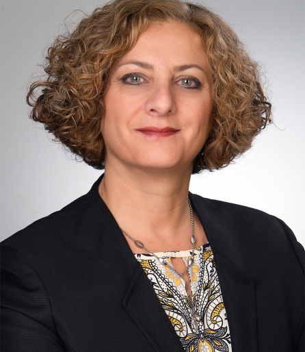 Portrait of a woman wearing a black blazer with short curly hair